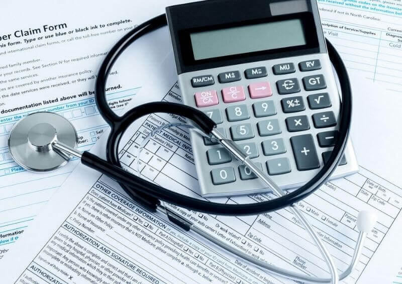 Stethoscope on top of calculator and claim forms