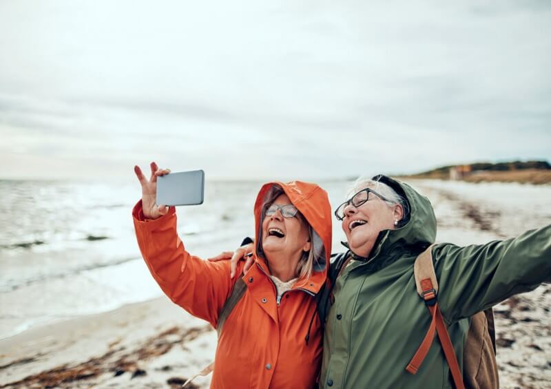 Two happy ladies taking a selfie on the beach