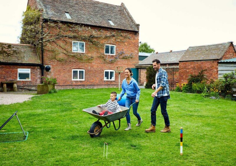 Two parents and their son having fun in their back garden