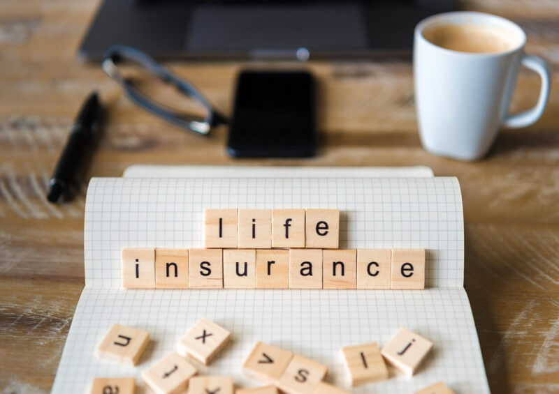 Wooden blocks spelling Life Insurance on desk